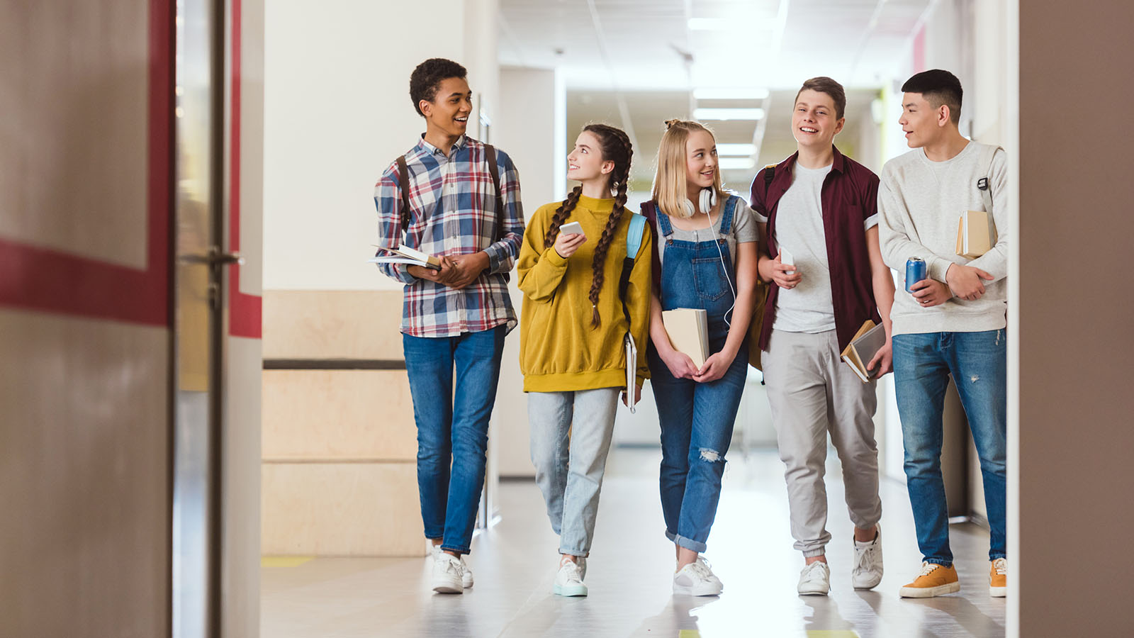 Children walking shoulder to shoulder in a hallway
